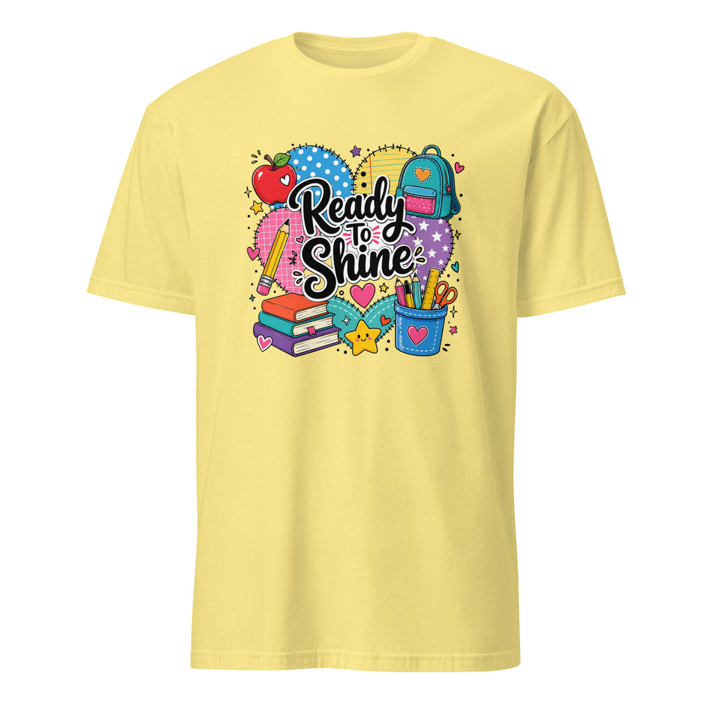 A pale yellow short-sleeve crewneck t-shirt featuring a colorful school-themed graphic on the chest with the text 'Ready to Shine' surrounded by school supplies like a backpack, books, an apple, and a pencil cup.