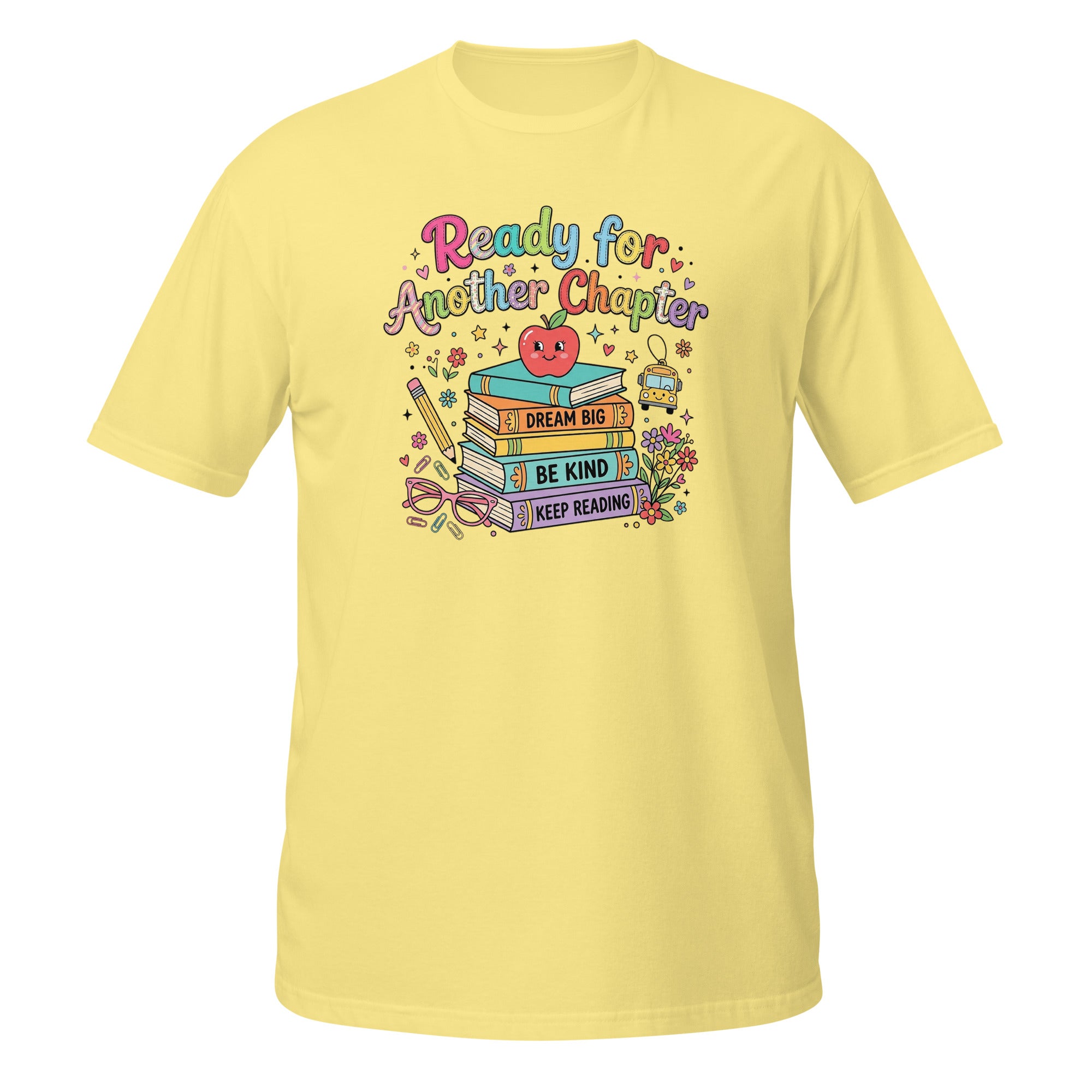 A light yellow short-sleeve t-shirt with a colorful graphic on the chest that reads 'Ready for Another Chapter' above a stack of books, a smiling apple, and school-themed illustrations.