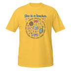 A daisy short-sleeve crewneck t-shirt featuring a colorful graphic on the front that reads 'She is a teacher' surrounded by school-themed illustrations like books, a globe, a magnifying glass, and bows.