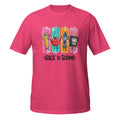 A bright pink short-sleeve t-shirt with a colorful 'Back to School' graphic on the chest, featuring cartoon drawings of a pencil, apple, crayon, and notebook over vertical paint strokes.