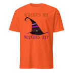 An orange short-sleeve crewneck t-shirt featuring a Halloween graphic with the text 'WHERE'S MY WITCHES AT?' in purple and a black witch hat with purple stripes.
