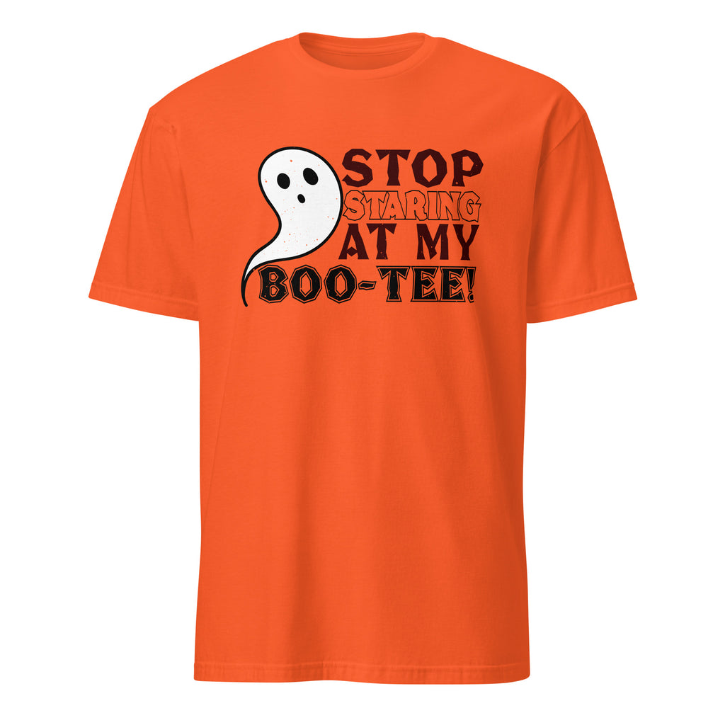 An orange short-sleeve crewneck t-shirt featuring a graphic on the chest with a white cartoon ghost and the text 'STOP STARING AT MY BOO-TEE!' in black and orange lettering, displayed on a solid white background.