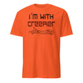 An orange short-sleeve crewneck t-shirt with a black graphic print on the front that reads 'I'm with creeper' above a line drawing of a skeletal arm pointing, shown on a plain white background.