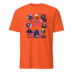 An orange short-sleeve crewneck t-shirt featuring a colorful graphic print on the front with various cute Halloween-themed illustrations, including pumpkins, a ghost, a mug, and a window, with the text 'Cozy Happy Halloween'.