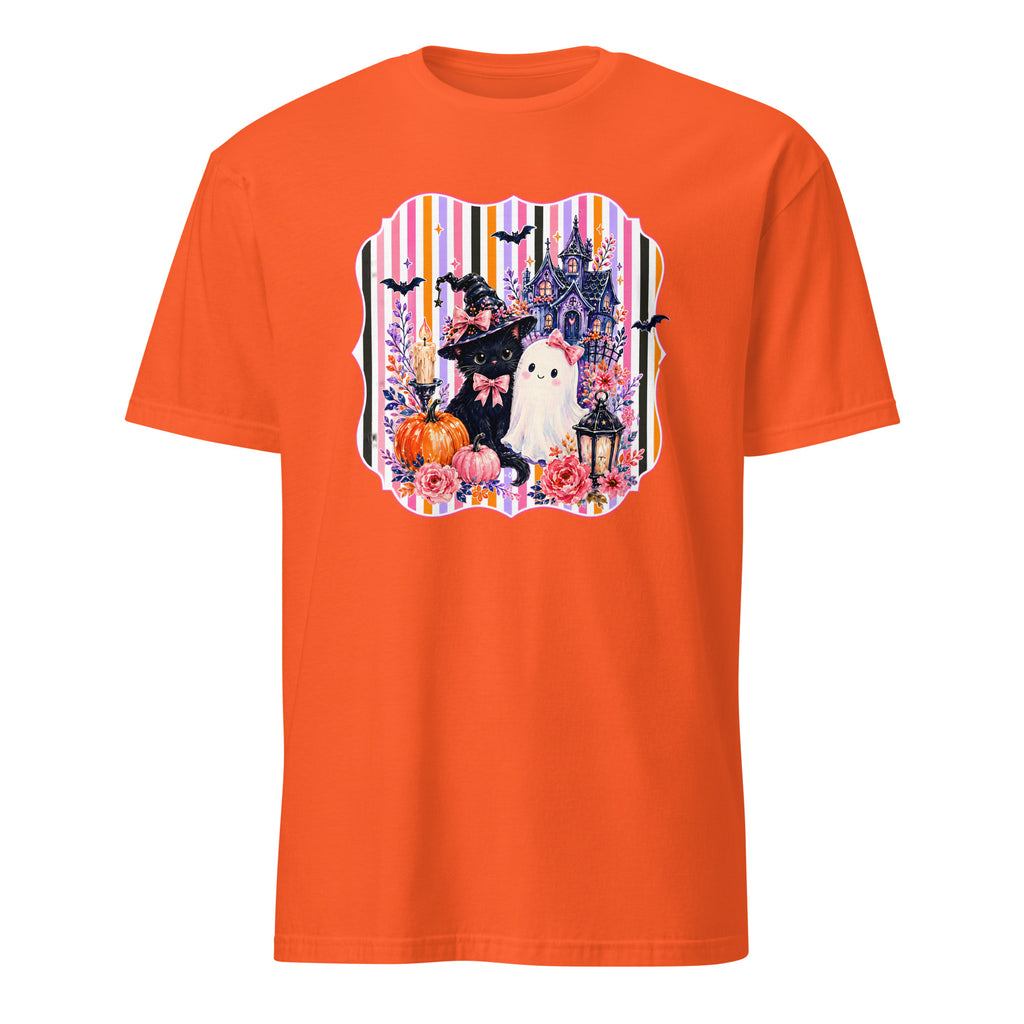 An orange short-sleeve crewneck t-shirt featuring a colorful Halloween-themed graphic print on the chest with a witch, ghost, castle, and pumpkins.