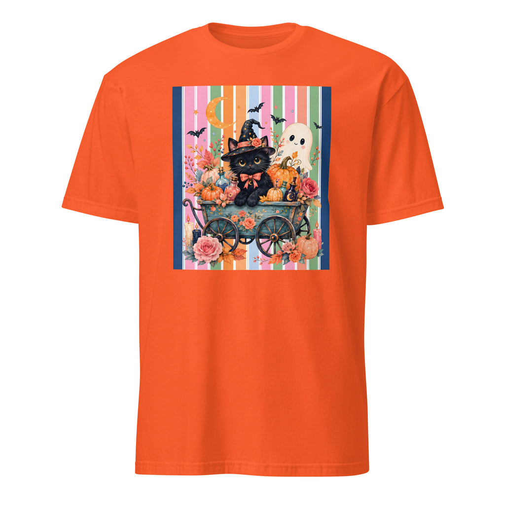 An orange short-sleeve crewneck t-shirt featuring a colorful Halloween-themed graphic print on the chest. The print depicts a black cat dressed as a witch in a cart with pumpkins, a white ghost, a moon, and bats against a striped background.
