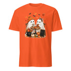 An orange short-sleeve crewneck t-shirt featuring a cute cartoon graphic of two white ghosts sitting at a small table with pumpkins, autumn leaves, and bats.