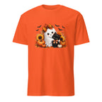 An orange short-sleeve crewneck t-shirt featuring a central graphic of a white ghost cat hugging a black kitten, surrounded by pumpkins, sunflowers, autumn leaves, and flying bats.