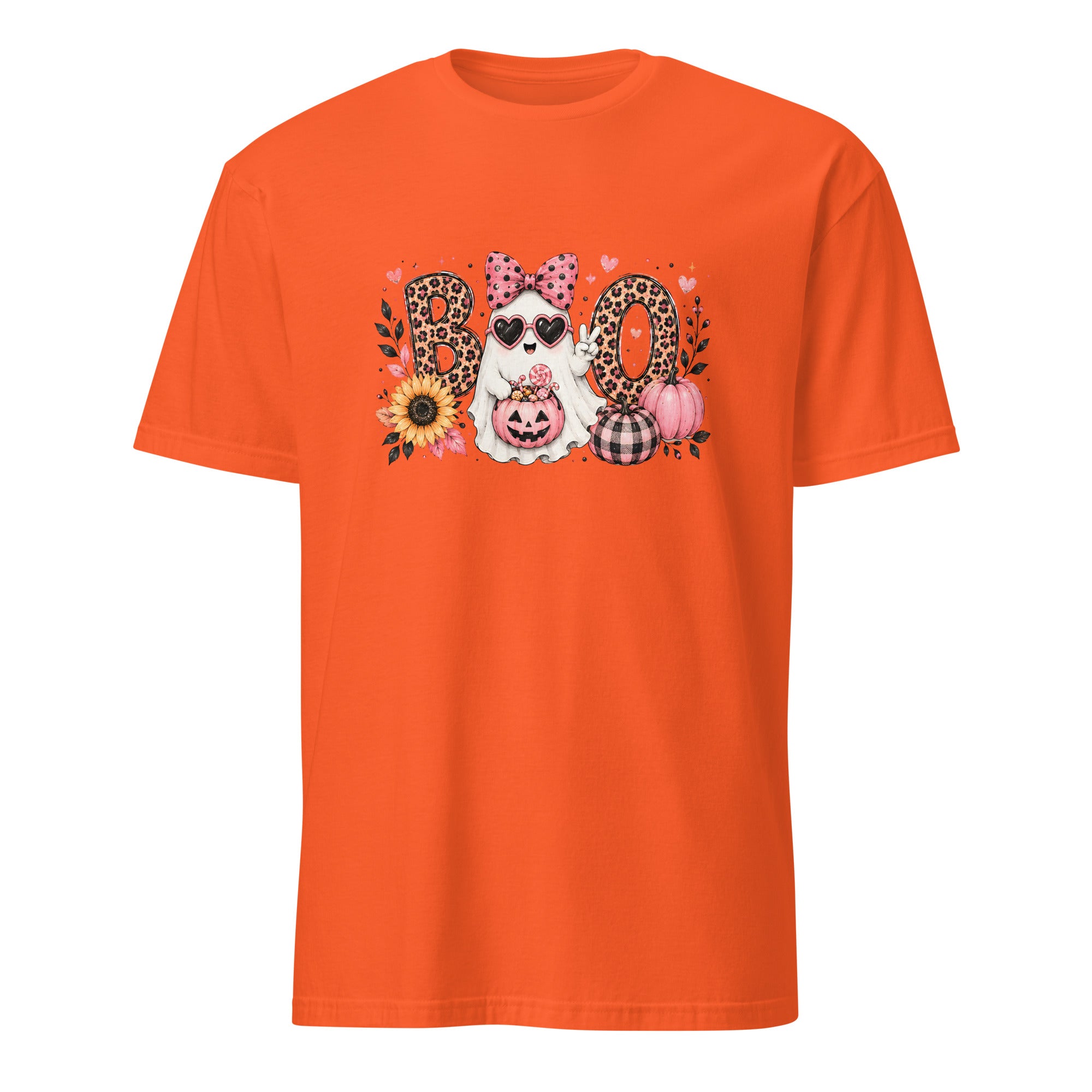 A bright orange short-sleeve crewneck t-shirt featuring a central graphic of a white dog wearing sunglasses and a pink polka-dot bow, surrounded by the word 'BOO' in leopard-print and plaid letters, with pumpkins, sunflowers, and hearts.
