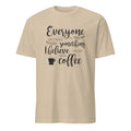 Sand  t-shirt with black Everyone Should Believe In Something, I Believe I Will Have Another Cup Of Coffee text and coffee cup graphic on a white background