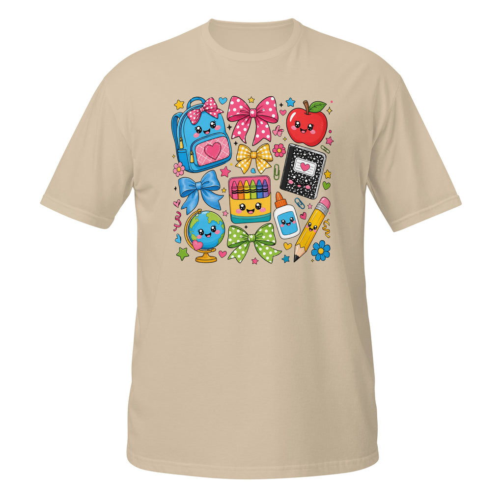 A beige short-sleeve crewneck t-shirt featuring a colorful cartoon school supplies graphic on the chest, including a blue backpack, red apple, bow, globe, and pencil on a white background.