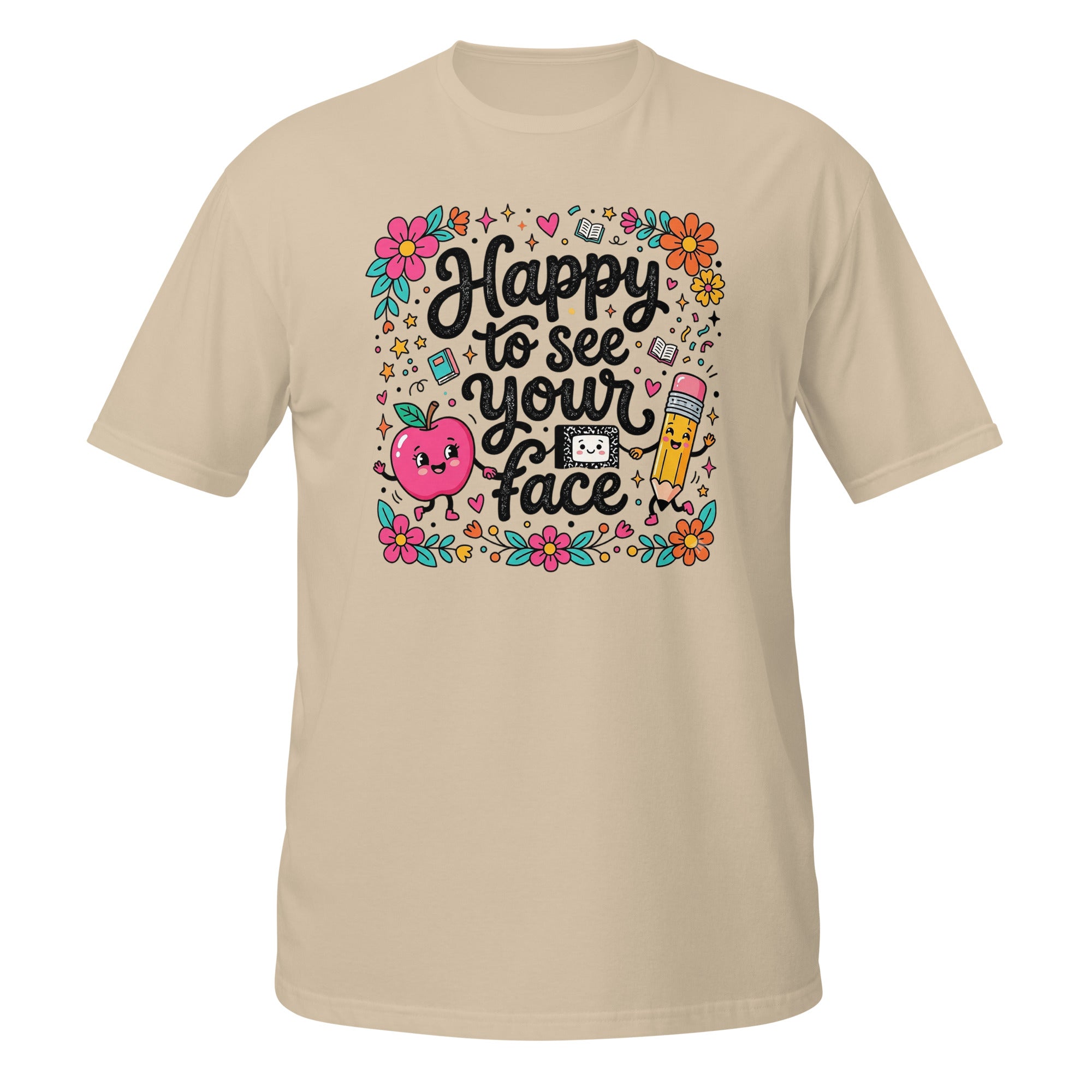 A beige short-sleeve t-shirt with a colorful graphic on the chest that reads 'Happy to see your face' in black script, surrounded by cute illustrations of a smiling pink apple, a yellow pencil, flowers, and school-themed doodles.
