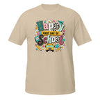 A beige short-sleeve crewneck t-shirt featuring a colorful 'Happy First Day of School' graphic on the chest, displayed against a solid white background.