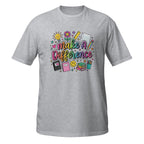 A heather gray short-sleeve crewneck t-shirt featuring a colorful graphic on the chest that reads 'Make A Difference' surrounded by school-themed doodles like a lightbulb, ruler, notebook, and pencils.