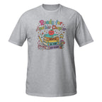A heather gray short-sleeve crewneck t-shirt featuring a colorful graphic on the chest with the text 'Ready for Another Chapter' above a stack of books, a smiling red apple, and motivational phrases like 'I Dream It', 'Be Kind', and 'Keep Reading'.