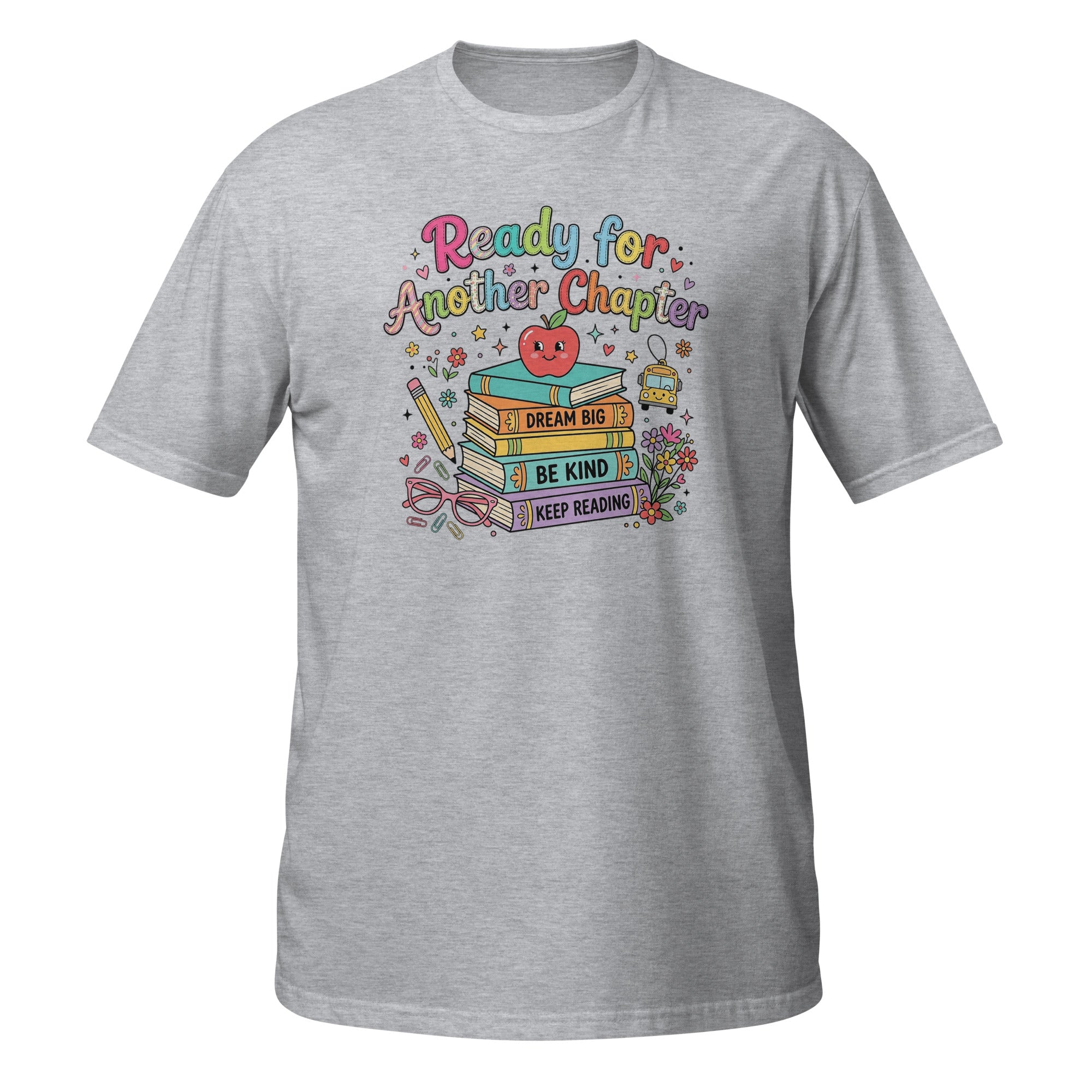 A heather gray short-sleeve crewneck t-shirt featuring a colorful graphic on the chest with the text 'Ready for Another Chapter' above a stack of books, a smiling red apple, and motivational phrases like 'I Dream It', 'Be Kind', and 'Keep Reading'.