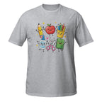 A heather gray short-sleeve t-shirt with a colorful graphic of cute, cartoon-style school supplies and a apple on the chest, displayed on a solid white background.
